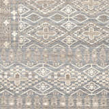 Close-up of the hand-knotted Woodsfield Premium Rug. Beige, brown, and gray geometric diamond and floral pattern. Wool texture. Swatch