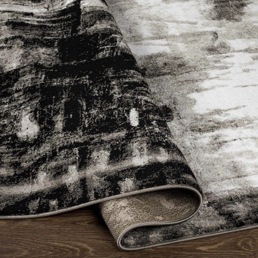 Close-up of the Westpoint Area Carpet showing its black, charcoal, gray, and off-white contemporary pattern and machine-woven texture. Fold