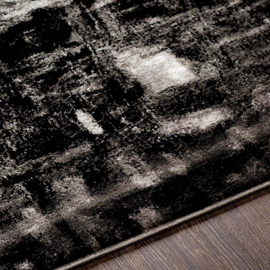 Close-up of the Westpoint Area Carpet showing a black, charcoal, and off-white contemporary pattern and soft texture. Texture