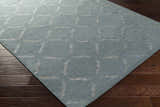 Close-up of Weybridge Area Carpet in light gray with a geometric square pattern on dark wood flooring. Corner