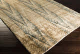 Close up of the Wilburton Jute Carpet showing its hand knotted texture and contemporary design with tan and gray chevron pattern. Corner