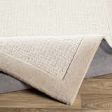 Close-up of the hand-tufted Winooski Area Rug. Cream and light gray wool with a solid, striped contemporary design. Fold