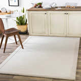 Light gray Winooski Area Rug in a dining room with a white table and wood chair. Roomscene-Rectangle