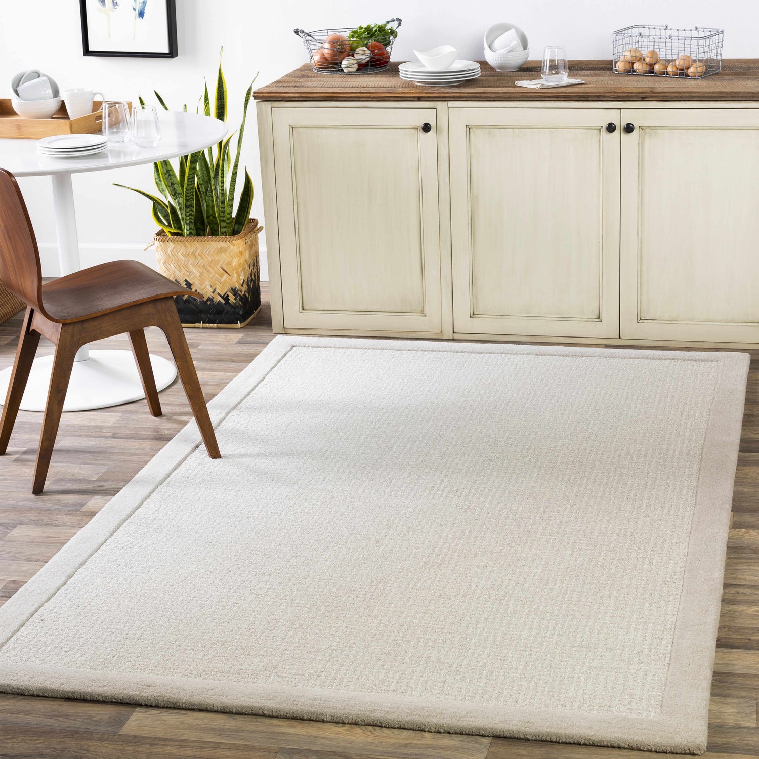 Light gray Winooski Area Rug in a dining room with a white table and wood chair. Roomscene-Rectangle