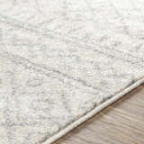 Close-up of the Winston Area Rug, a cream and gray rug with a subtle, textured pattern on light wood flooring. Texture