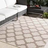 Patio scene with a beige Winterville Area Rug featuring a quatrefoil pattern, white sofa, and dark wicker table. Roomscene-Rectangle