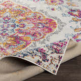 Wallsburg Magenta & Cream Area Rug close-up. Cream rug with magenta, saffron, and blue floral pattern. Polypropylene rug texture. Fold