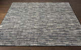 Close-up of the hand-knotted Willmar Premium Rug. Denim, ink blue, olive, and sage wool rug with a contemporary rectangular pattern. Front