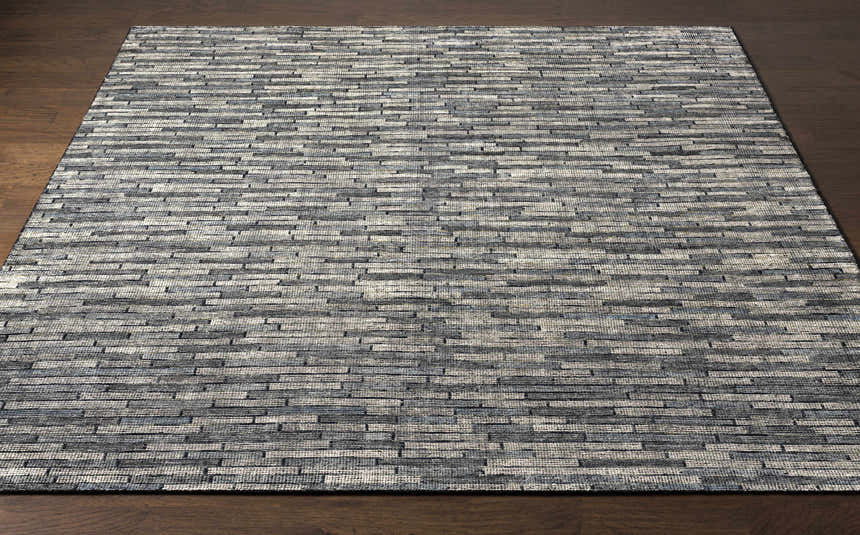 Close-up of the hand-knotted Willmar Premium Rug. Denim, ink blue, olive, and sage wool rug with a contemporary rectangular pattern. Front