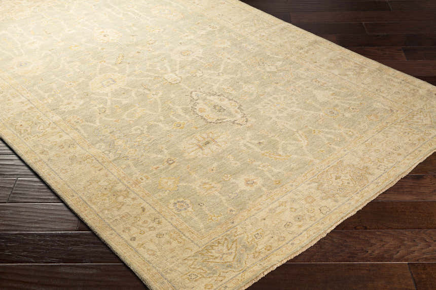Close-up of the hand-knotted Wooroloo Area Rug. Beige, olive, and yellow tones with a traditional oriental pattern. Corner
