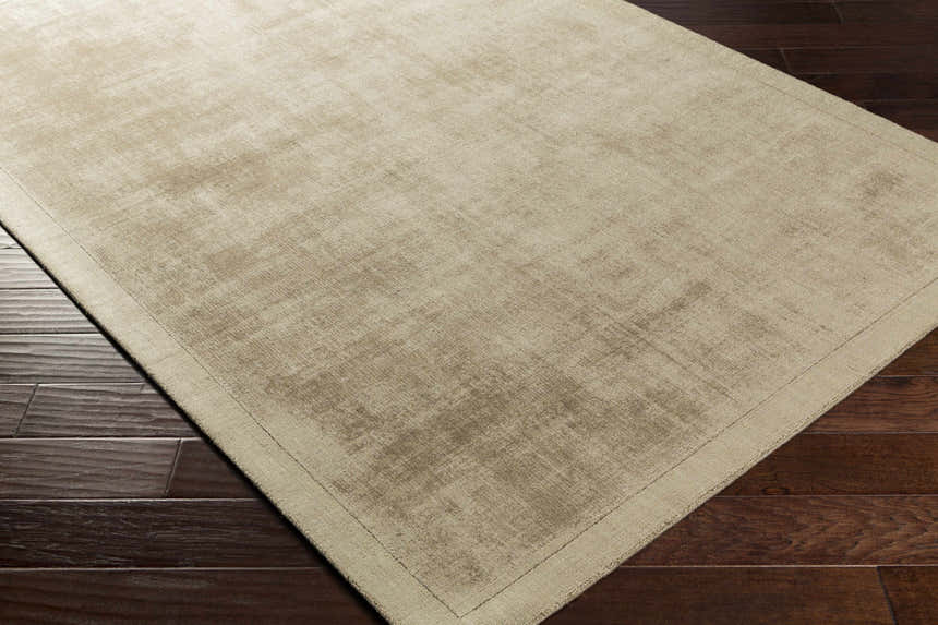 Close-up of the taupe Westbend Area Rug showing its subtle striped design and soft viscose texture on dark wood flooring. Corner