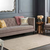 Living room scene with a taupe Westbend Area Rug, tufted sofa, and gray walls. Roomscene-Rectangle