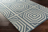 Close-up of the hand woven Westbrook Area Rug. Dark blue and light gray geometric pattern on a wool rug. Corner
