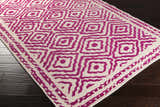Close-up of Westhill Area Carpet. Hand-knotted wool rug in fuchsia and light beige with a geometric square pattern. Corner