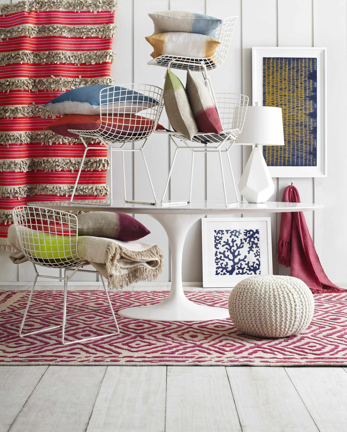 Eclectic room scene with a fuchsia and beige Westhill Area Carpet, white table, chairs, pillows, and artwork. Styleshot