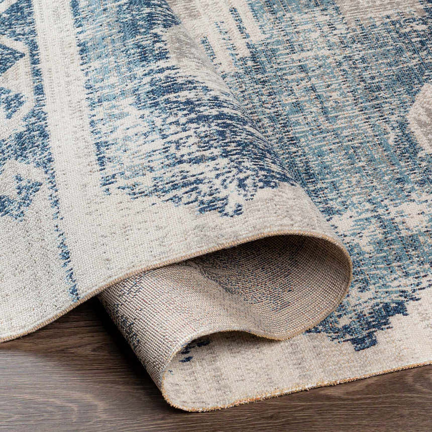 Close-up of the Westmount Denim Aztec Area Rug showing its cream, denim, and light gray colors and woven texture. Fold