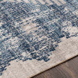 Close-up of the Westmount Denim Aztec Area Rug. Features a cream and denim blue abstract pattern and textured weave. Texture