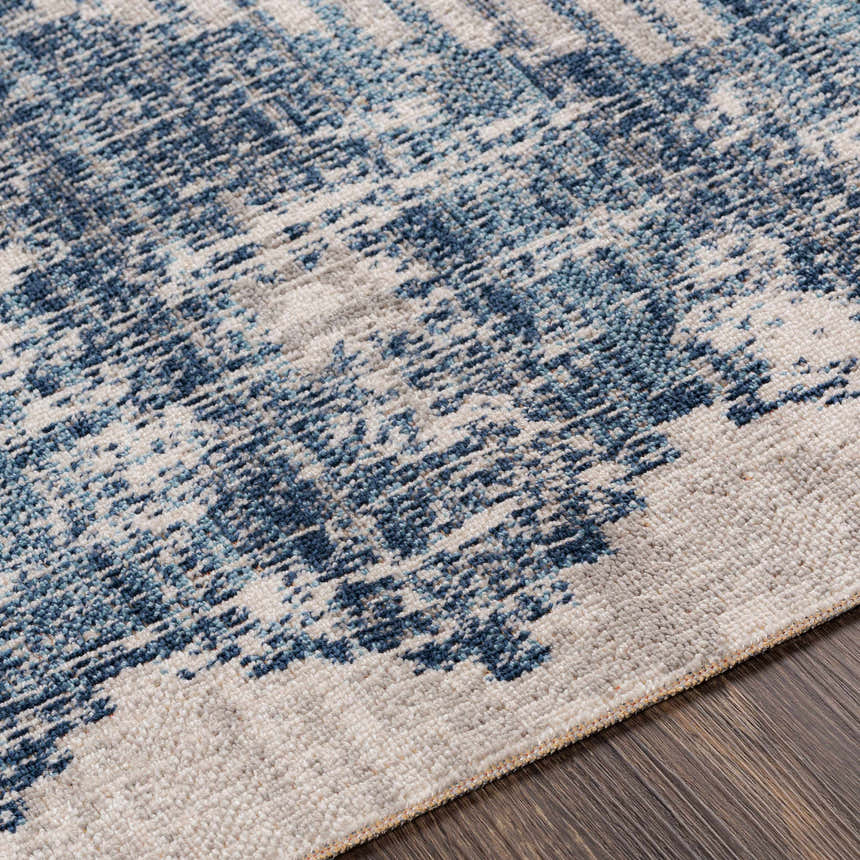 Close-up of the Westmount Denim Aztec Area Rug. Features a cream and denim blue abstract pattern and textured weave. Texture