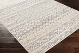 Close-up of the Westborough Beige Area Rug showing a contemporary blue geometric pattern on a cream background. Corner