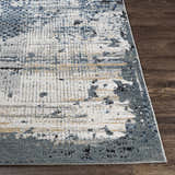 Close-up of the Waterboro Area Rug showing its abstract design in black, charcoal, blue, ivory, gray, and tan. Front