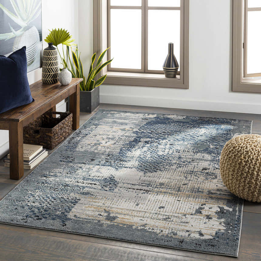 Living room scene with a blue and gray Waterboro Area Rug, wood bench, and natural light from windows. Roomscene-Rectangle