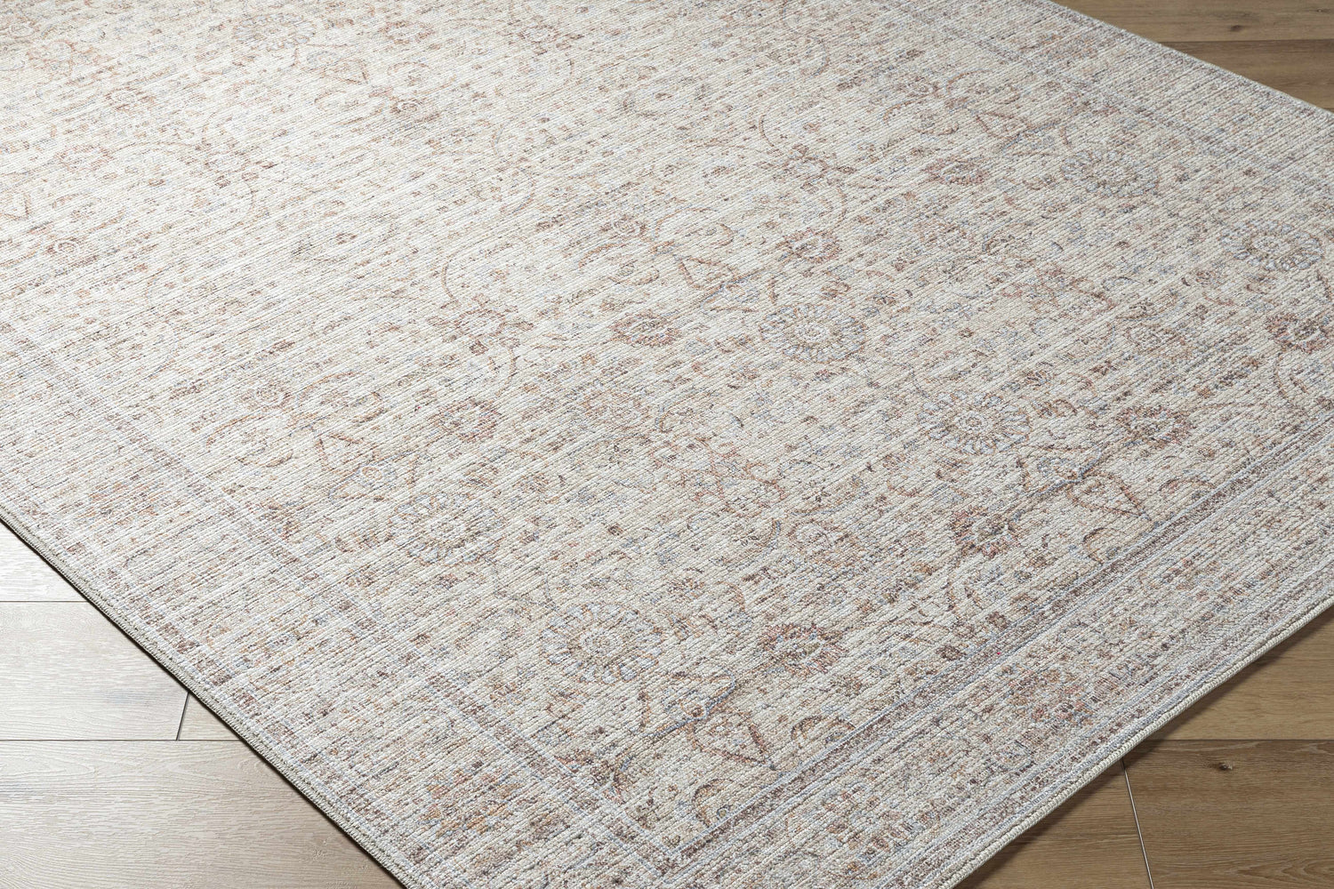 Close-up of the Xipil Area Rug. Traditional vintage style with dark red, ivory, and pale blue floral pattern. Corner