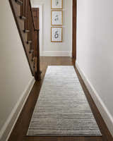 Hallway with dark wood floors and a Yemassee Tibetan Striped Area Rug in charcoal, ivory, and gray. Roomscene-Runner