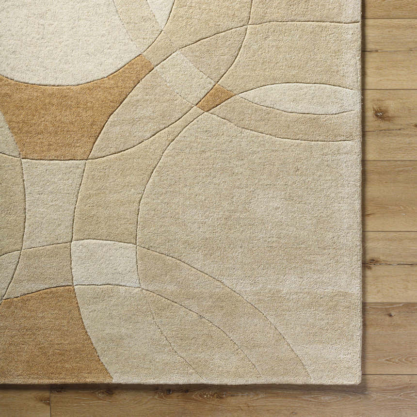 Close-up of the Yaxha Modern Wool Rug. Tan, camel, and warm gray hues with a contemporary geometric pattern. Hand-tufted texture. Corner