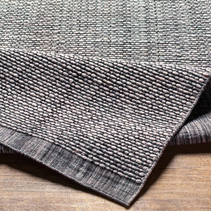 Close-up of the hand loomed Light Gray Area Rug, showing its textured weave and subtle charcoal and cream color variations. Fold