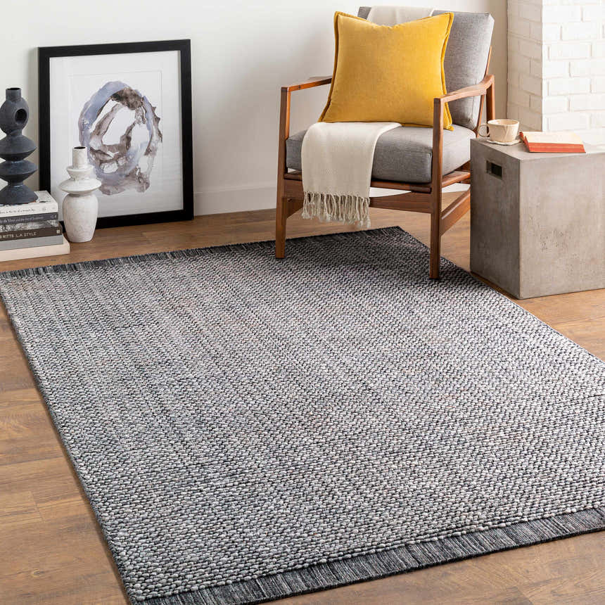 Living room scene with a hand loomed light gray area rug, gray chair, and modern decor. Roomscene-Rectangle