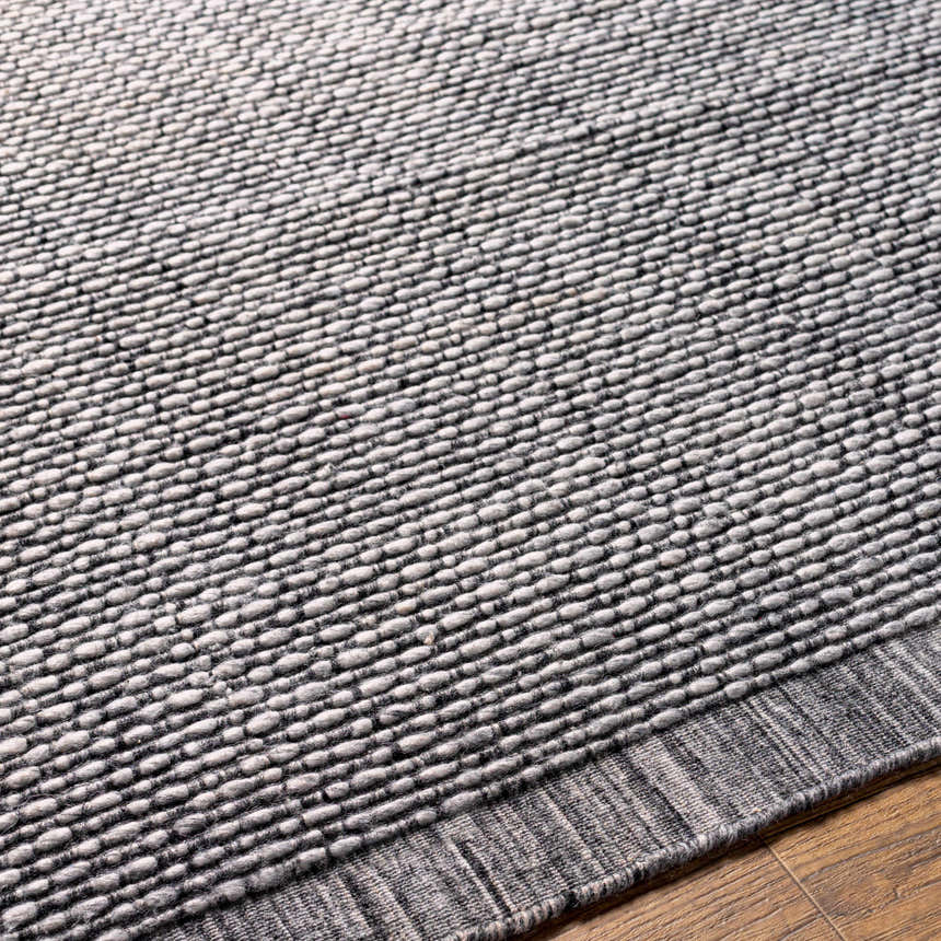 Close-up of the Hand Loomed Light Gray Area Rug, showing texture and pattern detail. Recycled PET yarn rug. Texture