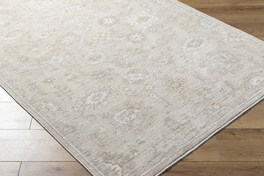 Close-up of the ash and light silver Yonca Luxe Rug, showcasing its traditional floral pattern and soft texture. Corner
