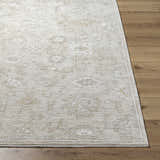 Close-up of the ash and light silver Yonca Luxe Rug showing its traditional pattern and polyester texture on wood floor. Front