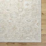 Close-up of the ash and light silver Yonca Luxe Rug showing the traditional, farmhouse-style pattern and woven texture. Corner