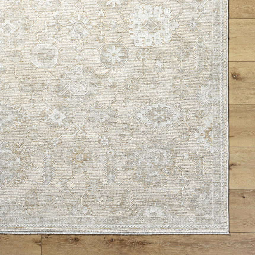 Close-up of the ash and light silver Yonca Luxe Rug showing the traditional, farmhouse-style pattern and woven texture. Corner