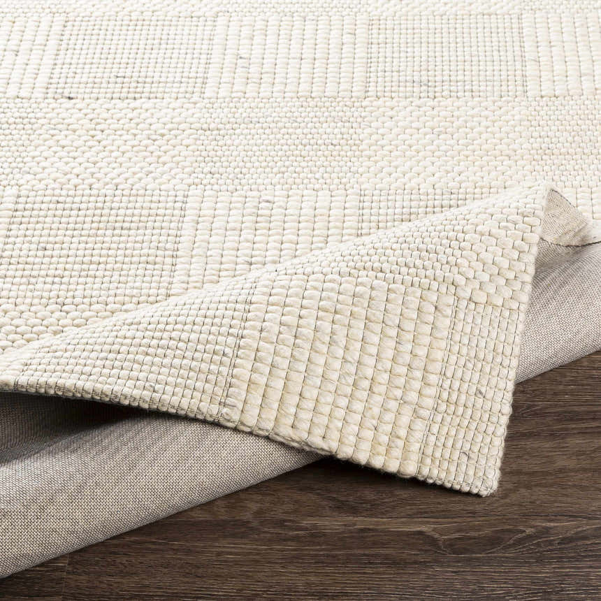 Close-up of the hand woven Yarrabilba Area Rug, showing the ivory wool texture and construction. Fold