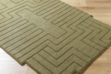 Close-up of the hand-loomed Yavor Green Geometric Area Rug showing its raised geometric pattern and wool texture. Corner