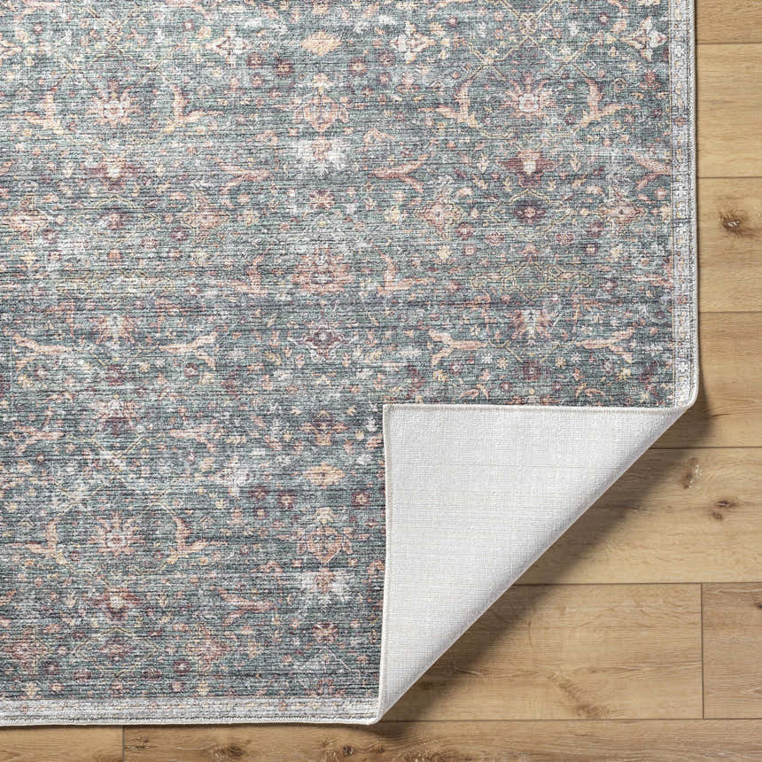 Close-up of the Zilya Area Rug featuring a traditional floral pattern in dark brown, green, peach, and rust hues. Fold