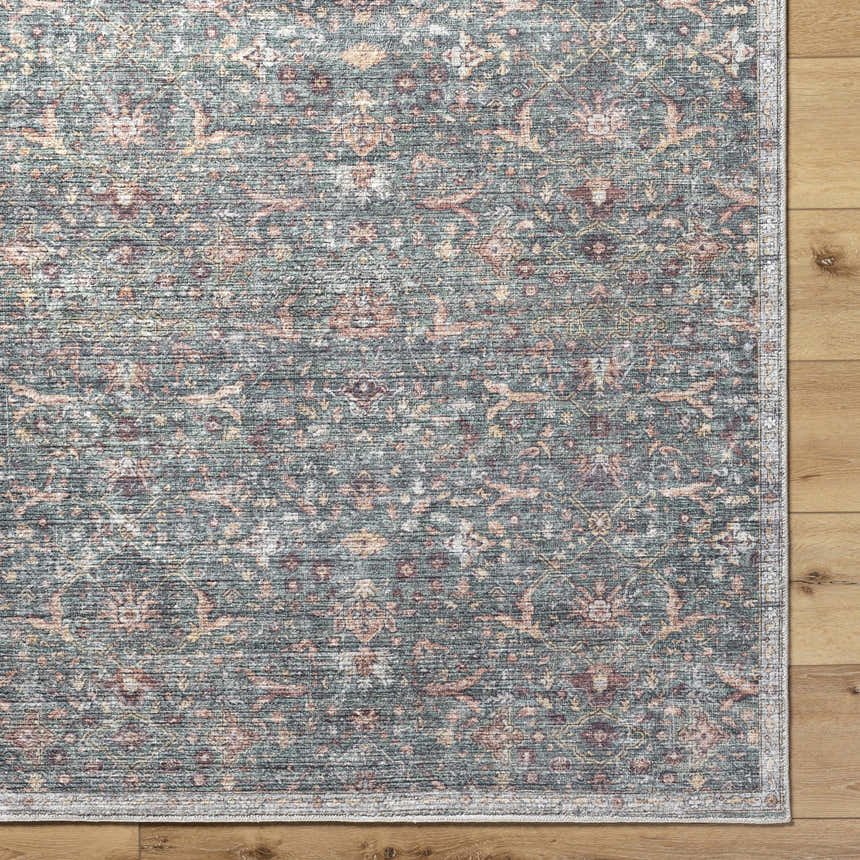 Close-up of the Zilya Area Rug showcasing its traditional floral pattern in dark brown, green, peach, and rust tones. Corner