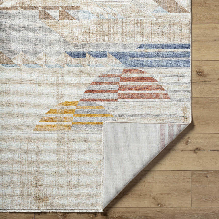 Close-up of the Zanna Area Rug showing geometric shapes in burnt orange, dark red, gray, ice blue, and white. Fold