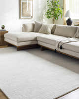 Living room with a light beige sectional sofa and Zareh Off White Solid Area Rug. Roomscene-Rectangle