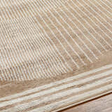 Close up of the Zeke Area Rug, showcasing a geometric pattern in bone, mocha, and brown hues. Texture