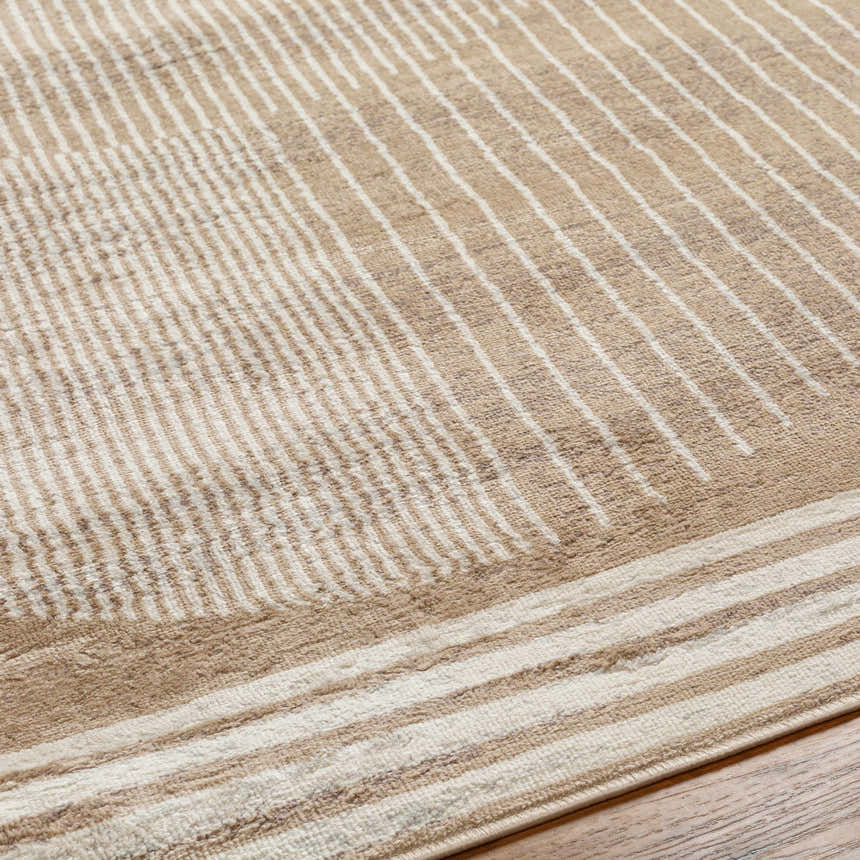 Close up of the Zeke Area Rug, showcasing a geometric pattern in bone, mocha, and brown hues. Texture