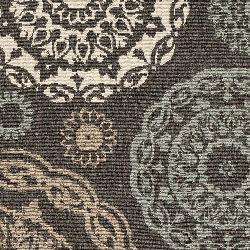 Close-up of Zephyrhills Area Rug showing beige, black, brown, dark red, and sage floral pattern and machine woven texture. Swatch