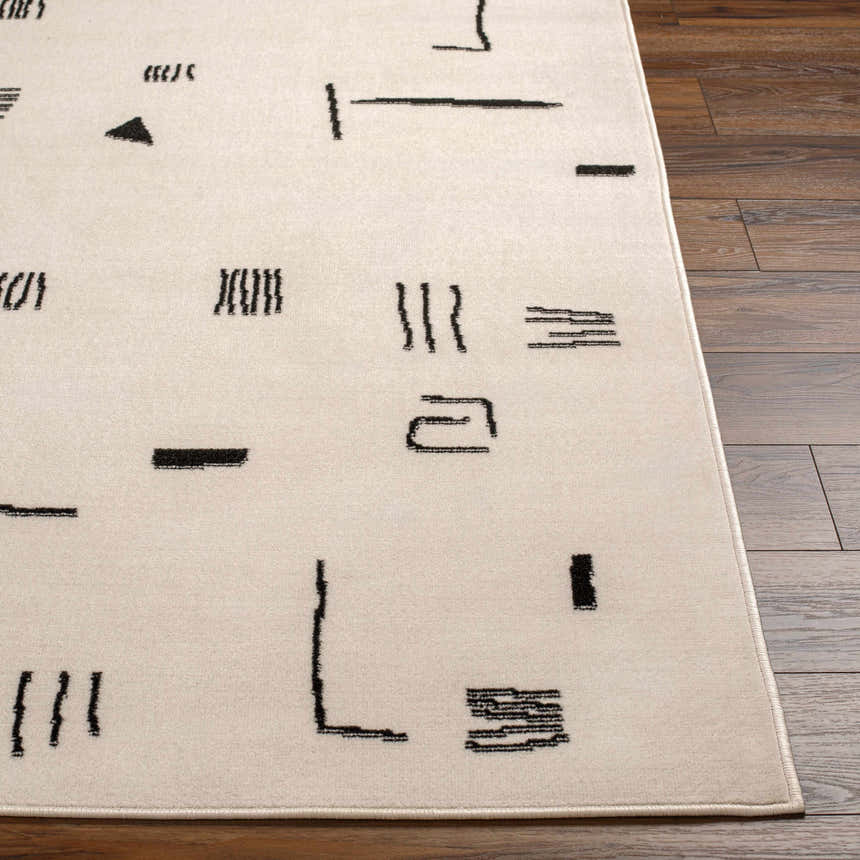 Close up of the Zale Area Rug showing a bone color with a dark gray, geometric pattern. Front