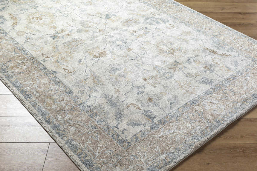Close-up of the Uriel Thick Luxe Rug. Beige, gray, and tan traditional pattern on a machine woven rug. Corner