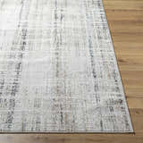 Close-up of the Zenon Area Rug showing its charcoal, light brown, and white abstract pattern and textured polypropylene weave. Front