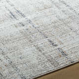 Close-up of the Zenon Area Rug showing its charcoal, light brown, gray, and white textured pattern. Texture
